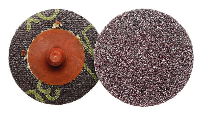 Two sanding discs, one with a brown center and green accents, the other with a textured surface, on a white background.
