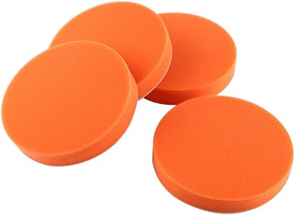 Four orange polishing pads on a white background